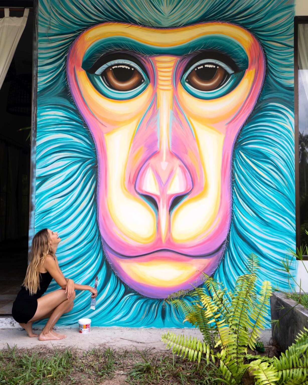 Ekaterina Sky painting a monkey mural, Animalize World Mural Tour